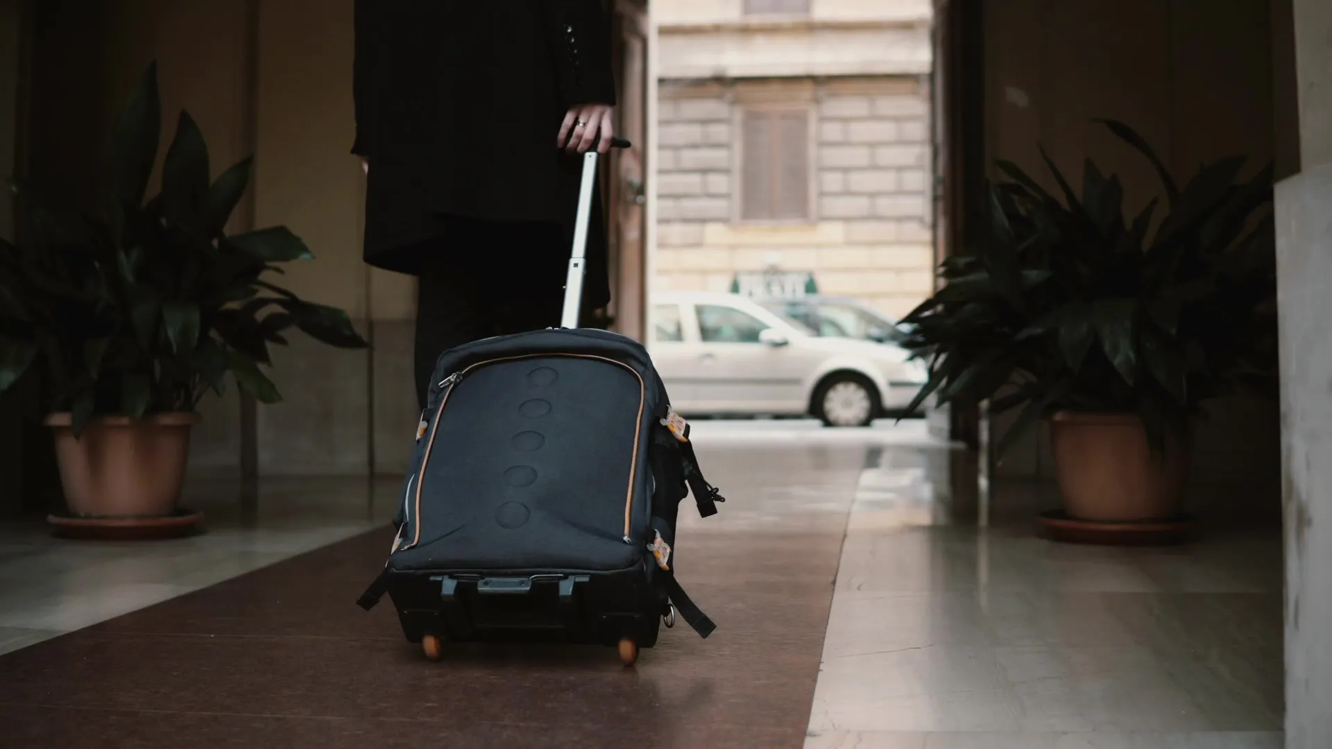 A traveller arriving in Romania with a suitcase for a dental trip