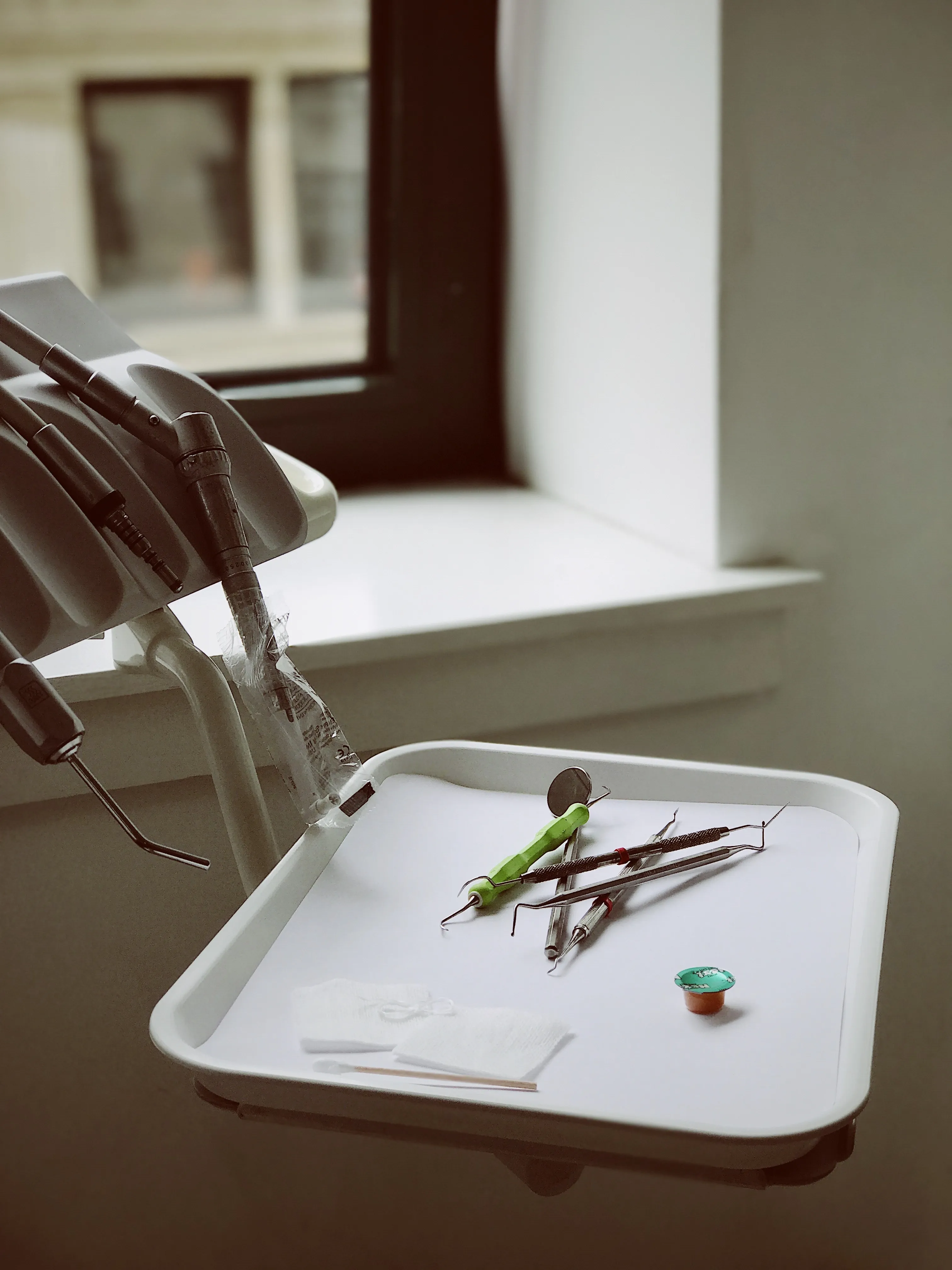 Sterile tray of dental hygiene instruments beside the chair