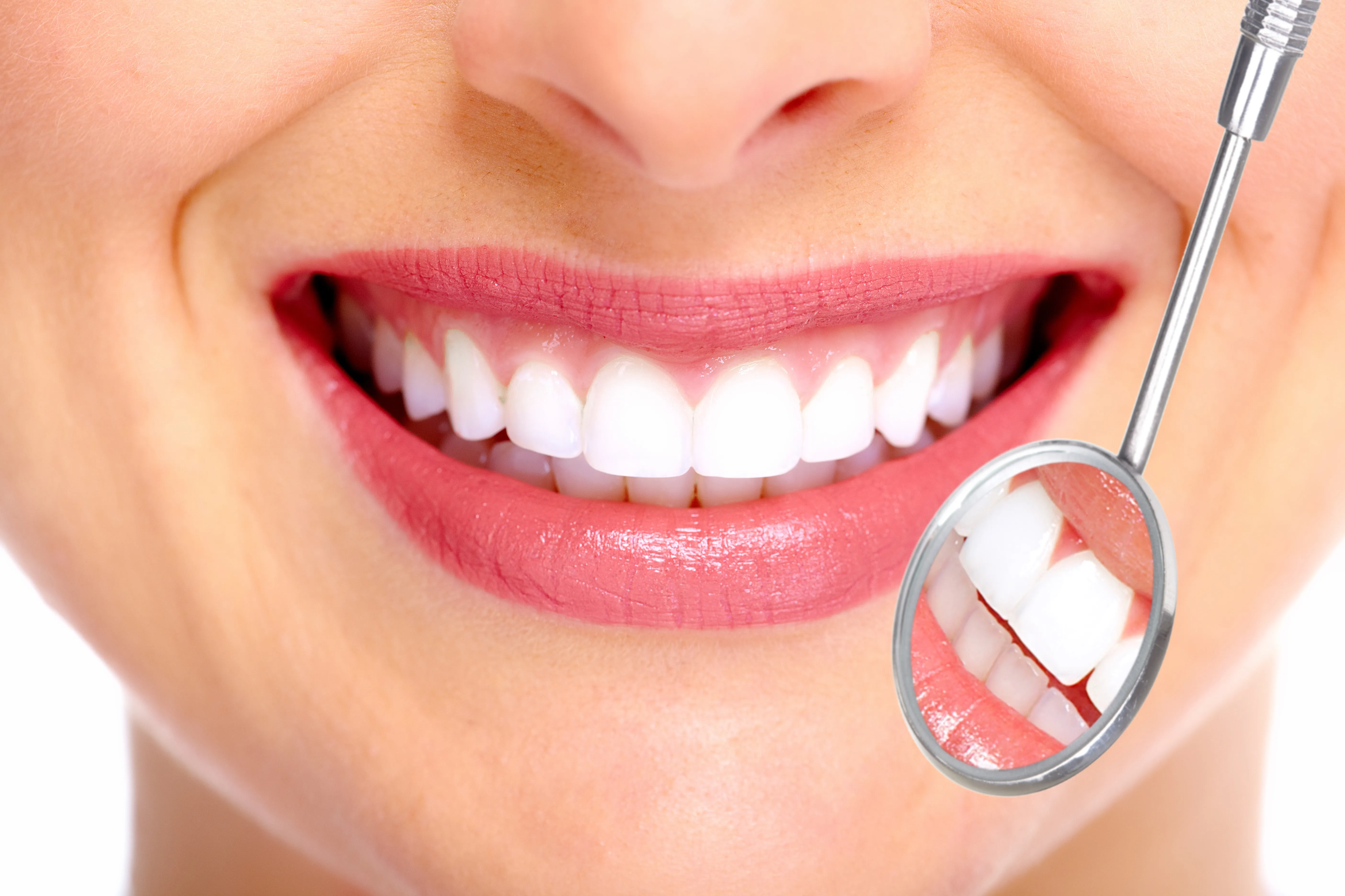 A bright, healthy smile checked with a dental mirror